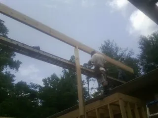 Carpenter setting a ridge beam over a new addition frame — Ice Dam Removal by Roofing Brothers in Outlook
