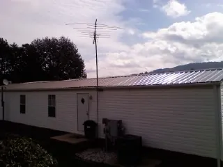 New metal roof on a single wide mobile home with a TV antenna in Outlook