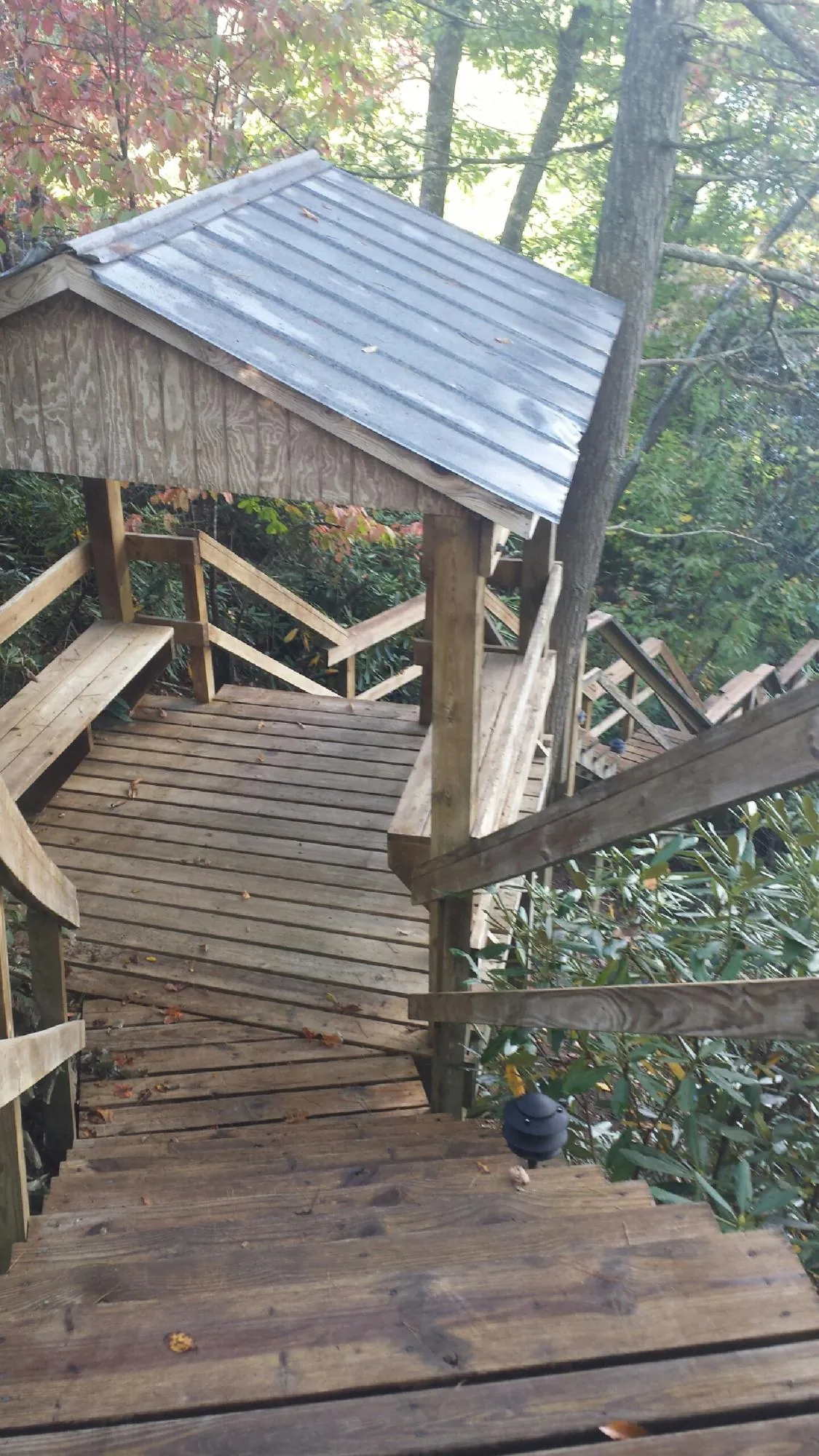 Metal roofed shelter over wooden steps on a wooded walkway — Skylight Repair & Installation work by our crew in Outlook