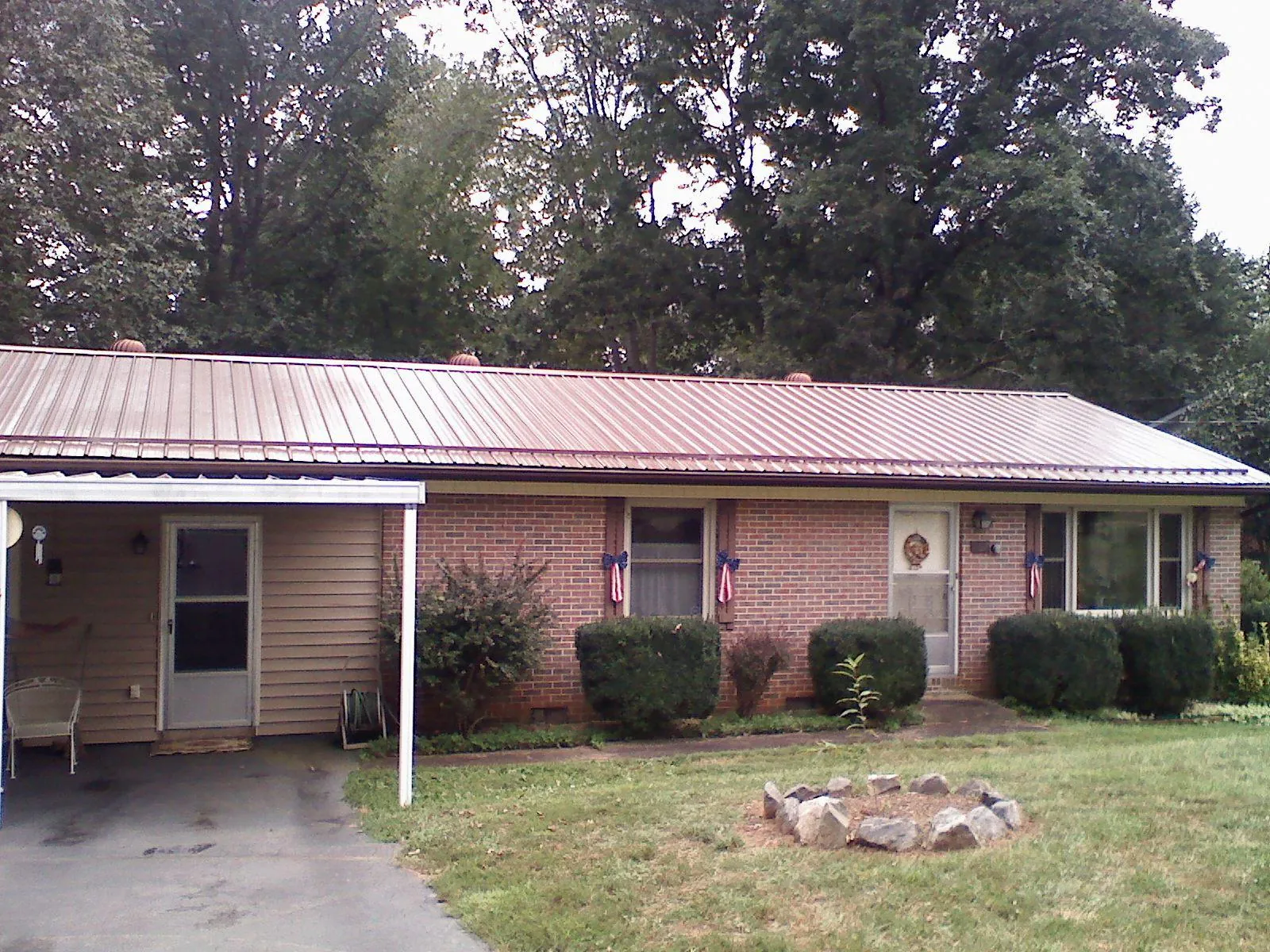 Bronze metal roof and carport on a brick ranch home — Roof Repair work by our crew in Outlook